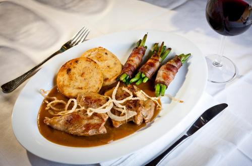 a plate of food with meat and sausage and a glass of wine at Gasthof "zur Bahn" in Lassnitzhöhe