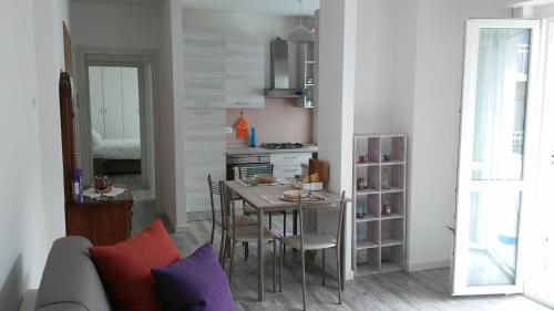 a living room with a table and a kitchen at Appartamento Miro in San Pellegrino Terme