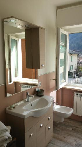 uma casa de banho com um lavatório, um espelho e uma banheira em Appartamento Miro em San Pellegrino Terme