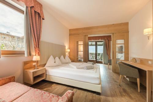 a bedroom with two beds and a desk and a window at Hotel Förstlerhof in Postal