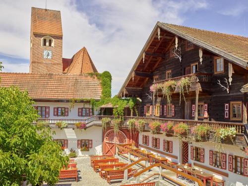a building with benches and a clock tower at Gutshof Uttlau in Haarbach