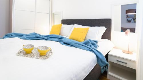 a white bed with two yellow bowls on it at Novel Inn in Belgrade