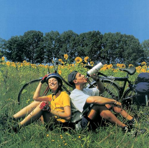 a man and woman sitting in a field with a telescope at Wolffhotel in Kopp