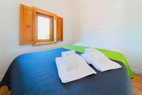a bedroom with a bed with towels on it at Aguda Beach Charming House By PortoProperties4You in Vila Nova de Gaia