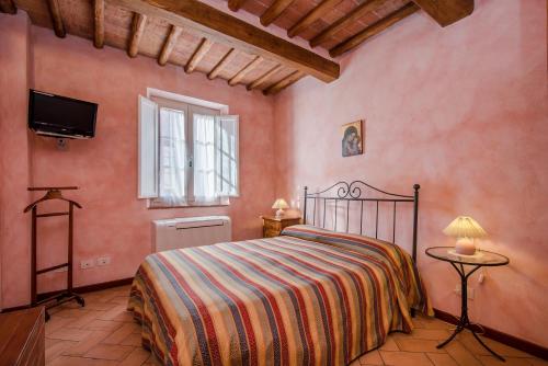 a bedroom with a bed and a tv on the wall at Casa Vacanze Il Campo in Siena