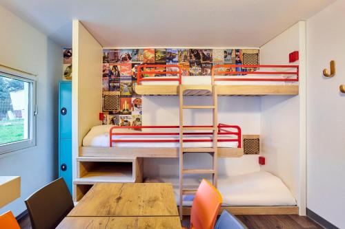 une chambre avec des lits superposés, une table et des chaises dans l'établissement hotelF1 Lille Metropole, à Mons-en-Baroeul