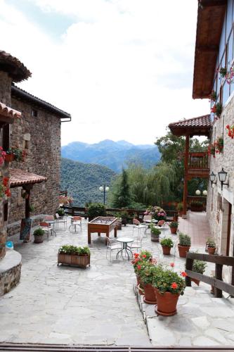 a patio with tables and chairs and potted plants at Viviendas Rurales Peña Sagra in Cahecho
