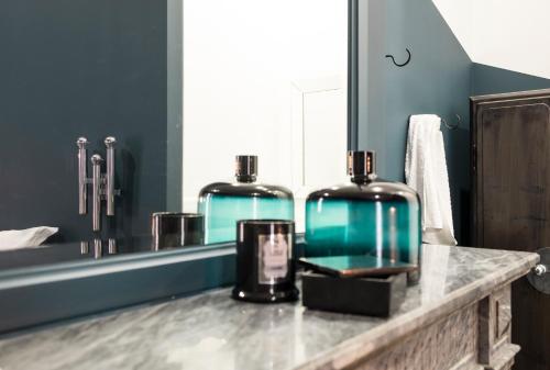 a bathroom with two bottles on a counter in front of a mirror at Wok Rooms in Brussels