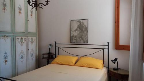 una camera con letto e cuscino giallo di Appartamento in villa a Fontane Bianche a Fontane Bianche