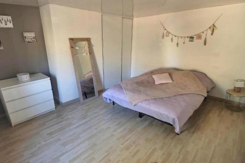 a bedroom with a bed and a dresser and a mirror at Le Grandthille in Chalons en Champagne