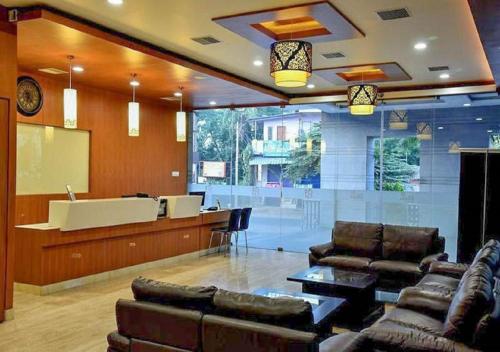 a lobby with couches and a bar in a building at Rathna Residency in Salem
