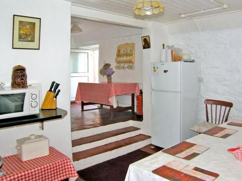 eine Küche mit einem weißen Kühlschrank und einem Tisch in der Unterkunft Carthy's Cottage in Kilbrien