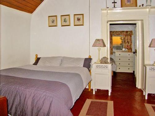 Schlafzimmer mit einem Bett, einer Kommode und einem Spiegel in der Unterkunft Carthy's Cottage in Kilbrien
