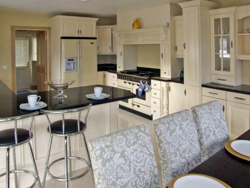 a kitchen with white cabinets and bar stools at River House in Hollywood