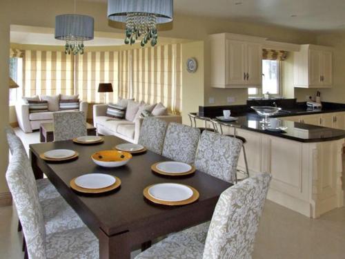 a dining room table with chairs and a kitchen at River House in Hollywood