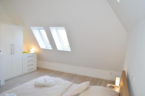 Dünenmeer في جويست: غرفة نوم بيضاء مع سرير وخزانة