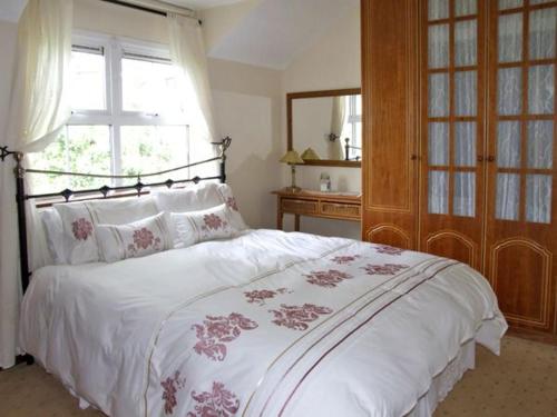 a bedroom with a large white bed with a window at 4 Bell Heights Apartments in Kenmare