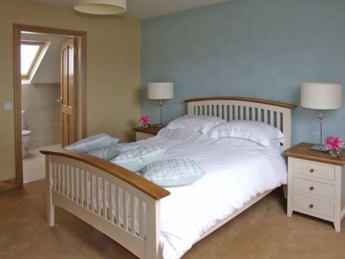 a bedroom with a large bed with white sheets and pillows at River House in Hollywood