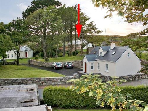 ein Haus mit einer roten Flagge darüber in der Unterkunft 2 Clancy Cottages in Kilkieran