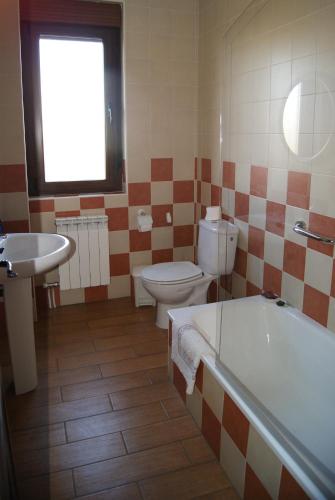 La salle de bains est pourvue d'une baignoire, de toilettes et d'un lavabo. dans l'établissement Hotel Rural Casa El Cura, à Calzadilla de los Hermanillos
