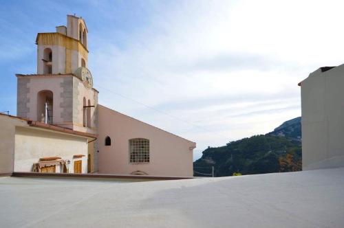 a church with a clock tower on top of a building at Casa Pont1 in Scala