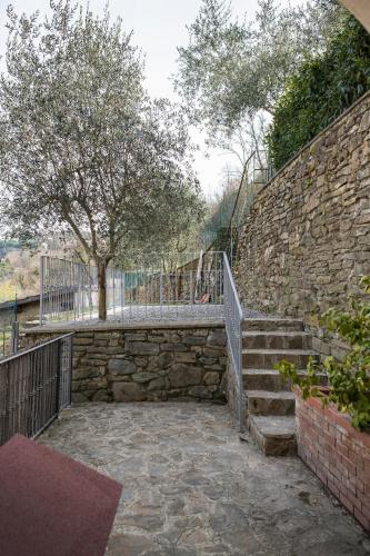 a stone stairway with a stone wall and a tree at Rocca Palazzaccio in Impruneta