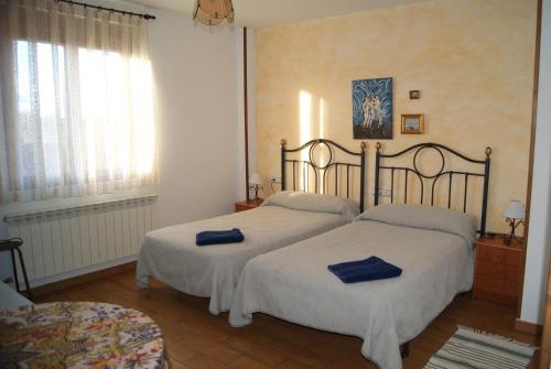 a bedroom with two beds with blue towels on them at Hotel Rural Casa El Cura in Calzadilla de los Hermanillos