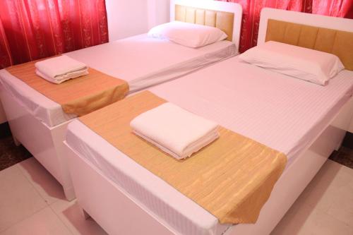 three beds in a room with white sheets at Butuan Grand Palace Hotel Annex in Butuan
