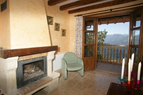 a living room with a fireplace and a chair at Viviendas Rurales Peña Sagra in Cahecho