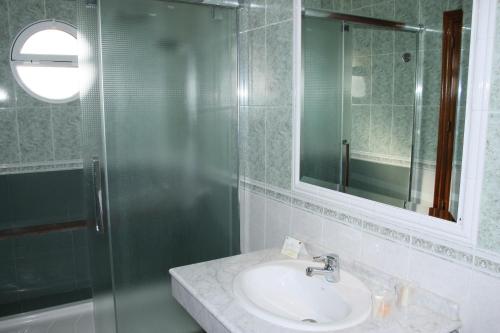 a bathroom with a sink and a glass shower at Hotel Frijon in Aceuchal