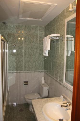 a bathroom with a toilet and a sink at Hotel Frijon in Aceuchal