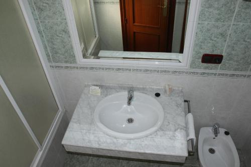 a bathroom with a white sink and a toilet at Hotel Frijon in Aceuchal