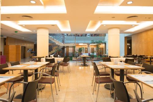 a restaurant with tables and chairs in a room at VIP Executive Entrecampos Hotel & Conference in Lisbon