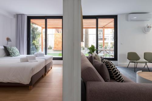 een woonkamer met een bed en een bank bij Lisbon Domus 74 by amcf in Lissabon