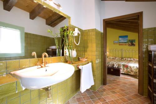 a bathroom with a sink and a bedroom at Hotel Rural El Pilaret in Azanúy