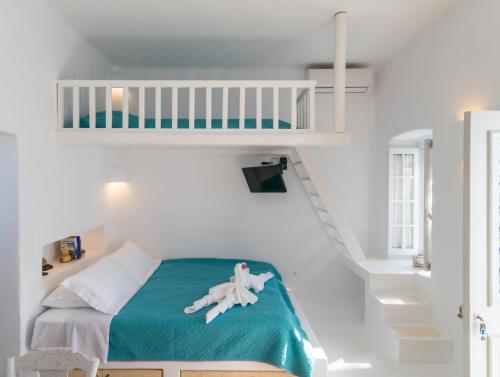 Mandrakia的住宿－Traditional House by the Sea，白色的卧室设有双层床和梯子