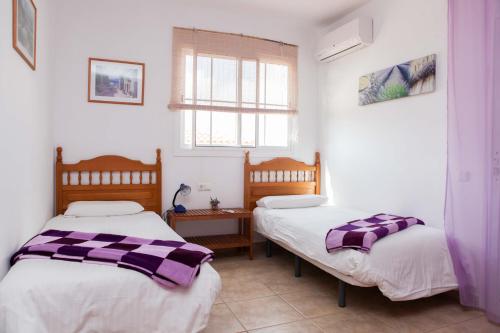 a bedroom with two beds and a window at Villa Musica in Caleta De Fuste