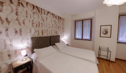 a bedroom with a white bed and a wall with writing at Hotel Miramare & Spa in Sestri Levante