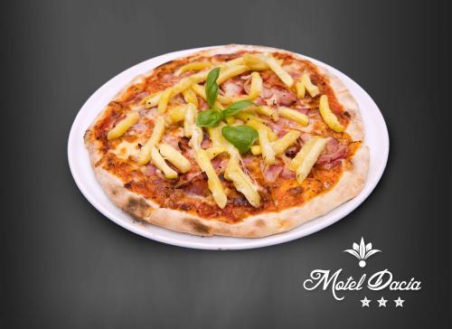 a pizza on a white plate on a table at Motel Dacia in Sebeş