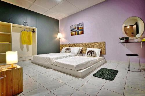 a bedroom with a large bed and a mirror at Home Art 103 in Ipoh