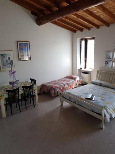 Schlafzimmer mit einem Bett und einem Tisch mit Stühlen in der Unterkunft Casa Bagatta in Desenzano del Garda