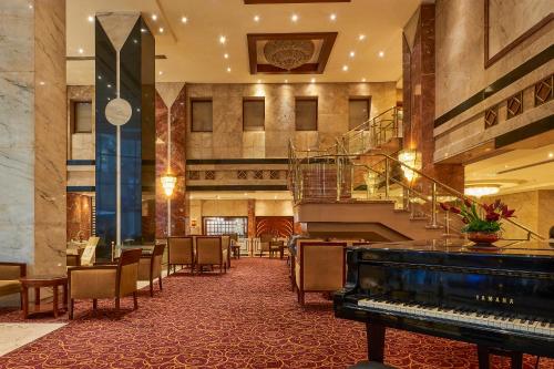 a hotel lobby with a piano and a staircase at Safir Hotel Cairo in Cairo