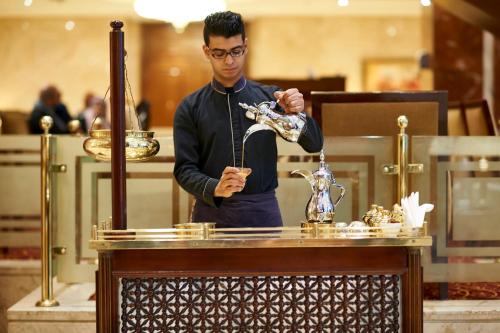 a man standing behind a table with a pipe at Safir Hotel Cairo in Cairo