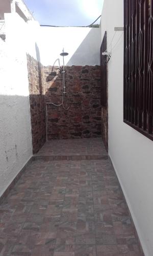 Cette chambre dispose d'un mur en briques et d'une douche. dans l'établissement Casa Pina, à Cala Gonone