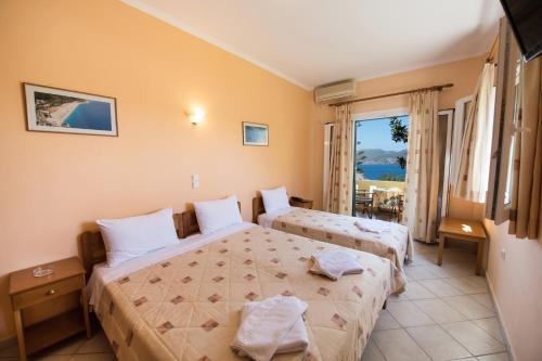 a hotel room with two beds and a balcony at Sofia Hotel in Nikiana