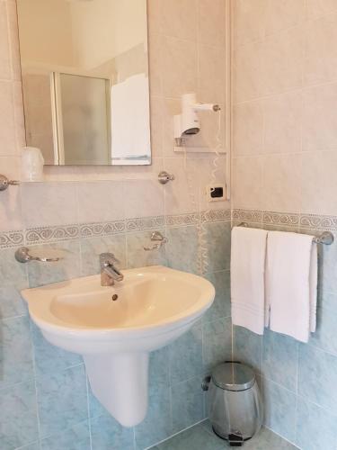 a bathroom with a sink and a mirror and towels at Alla Torretta in Bellagio