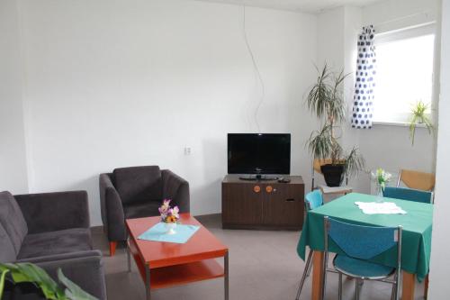 un soggiorno con tavolo, sedie e TV di Hostel Turist a Zvolen