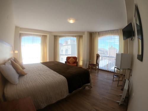 a hotel room with a bed and windows and a television at Sol Plaza Hotel in Puno