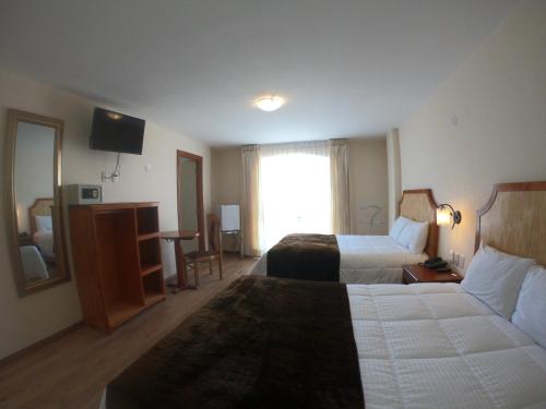 a hotel room with two beds and a television at Sol Plaza Hotel in Puno
