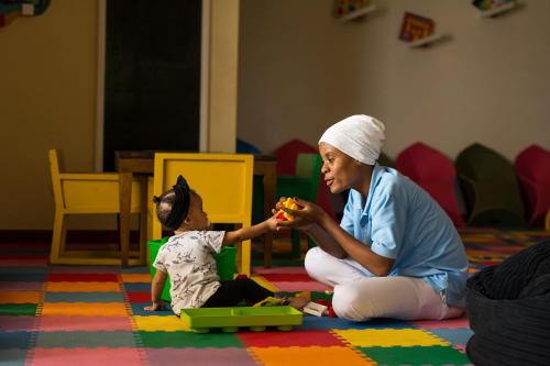 a woman feeding a child a piece of food at Essque Zalu Zanzibar in Nungwi
